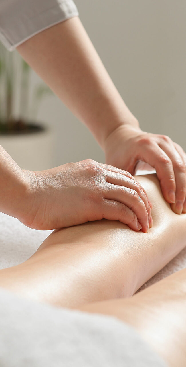 Woman receiving leg massage in spa salon, closeup